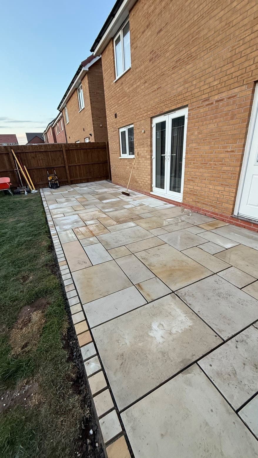 Paved patio installation in the rear garden of a new-build brick house, detail
